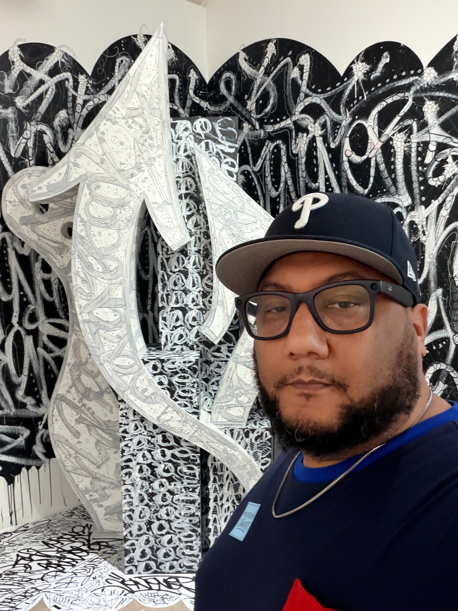 Chris Still, creator of Stillife Project, in front of a black-and-white art installation